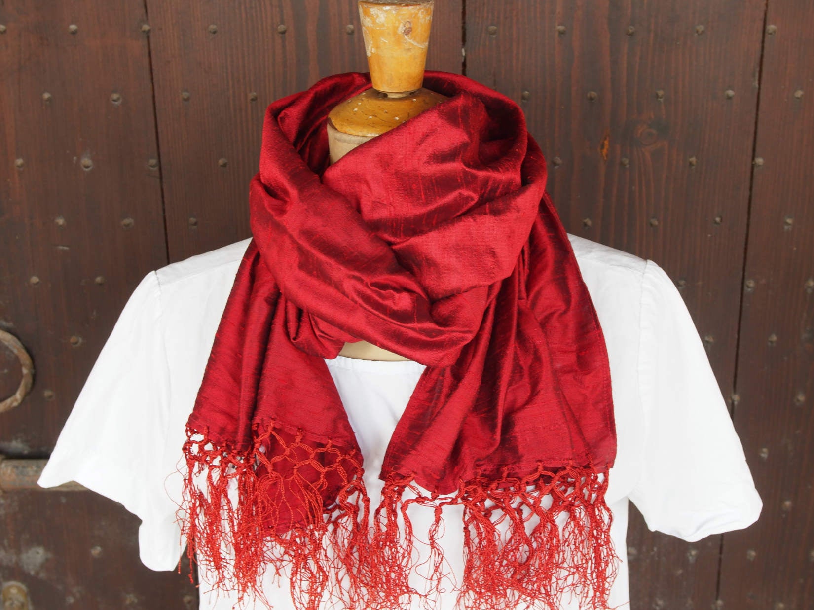 Scialle indiano in shantung di seta , un tessuto di seta selvaggia, di colore unito, caratterizzato da una superficie ruvida, molto irregolare e dall'aspetto grezzo di colore rosso.