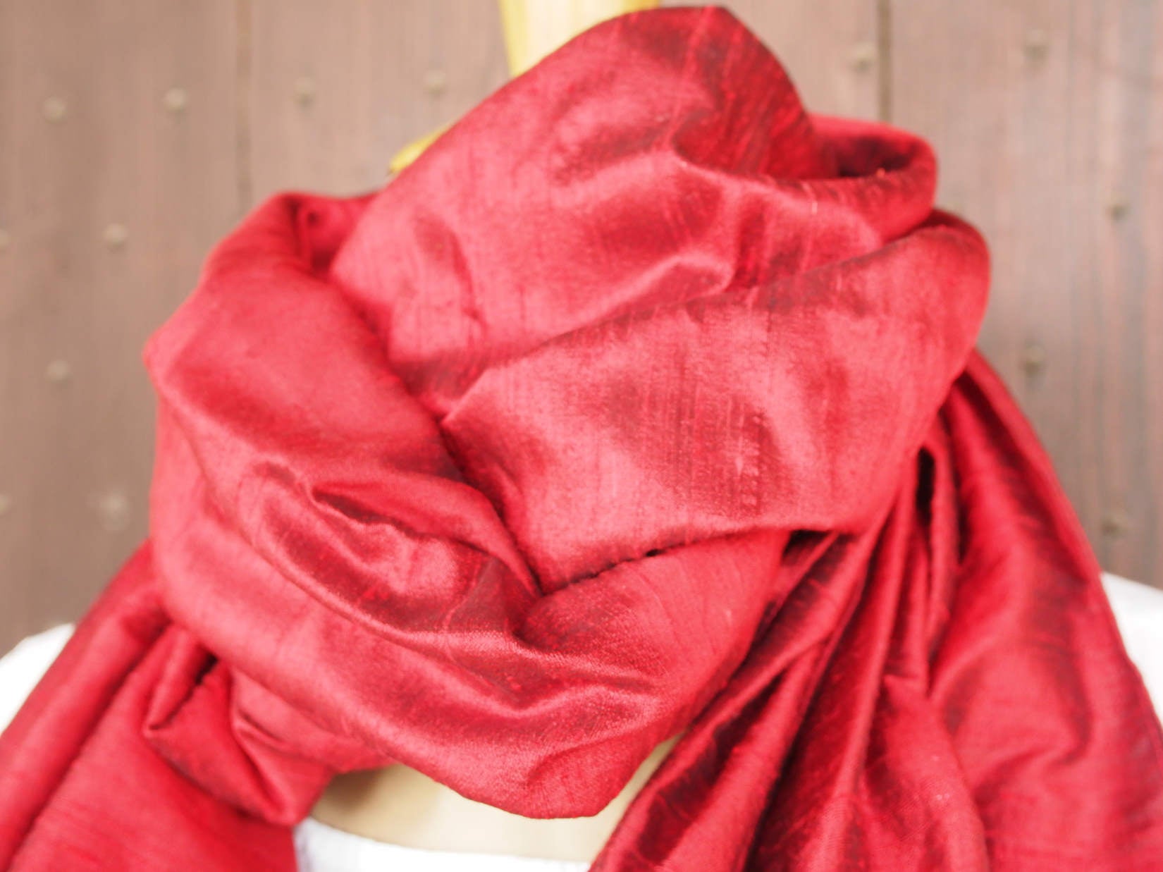 Scialle indiano in shantung di seta , un tessuto di seta selvaggia, di colore unito, caratterizzato da una superficie ruvida, molto irregolare e dall'aspetto grezzo di colore rosso.