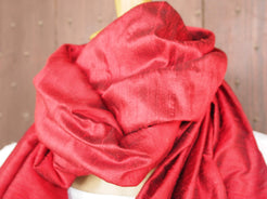 Scialle indiano in shantung di seta , un tessuto di seta selvaggia, di colore unito, caratterizzato da una superficie ruvida, molto irregolare e dall'aspetto grezzo di colore rosso.