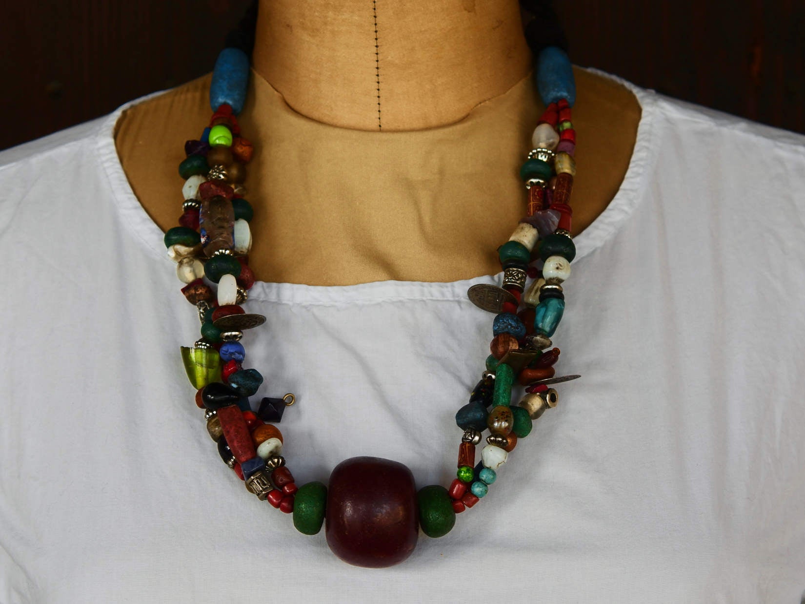 Collana tribale Amazigh, Berbera. Fatta a mano da artigiani berberi tradizionali con perline in ceramica, cristalli, pelle, pietre, corna, resine vegetali naturali e alcune piccole monete vecchie. La pietra centrale di un colore giallo intenso è di diametro 4cm circa, è leggermente ovalizzata. Pezzo unico di origine tribale , disponibili altri modelli oltre a quelli fotografati.  lunghezza 70cm, peso 170 gr