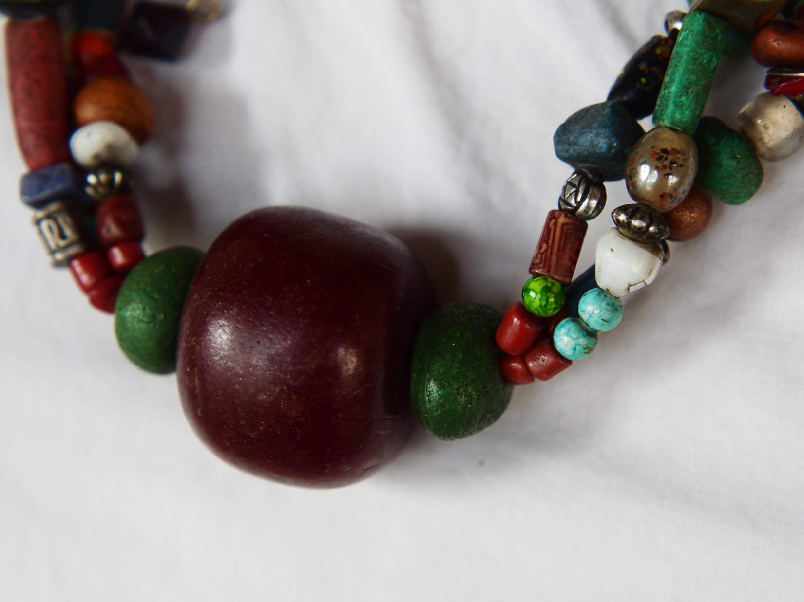 Collana tribale Amazigh, Berbera. Fatta a mano da artigiani berberi tradizionali con perline in ceramica, cristalli, pelle, pietre, corna, resine vegetali naturali e alcune piccole monete vecchie. La pietra centrale di un colore giallo intenso è di diametro 4cm circa, è leggermente ovalizzata. Pezzo unico di origine tribale , disponibili altri modelli oltre a quelli fotografati.  lunghezza 70cm, peso 170 gr