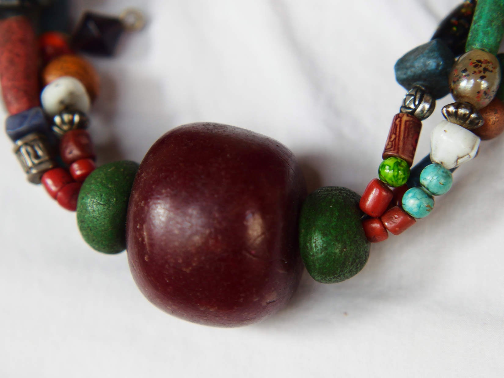 Collana tribale Amazigh, Berbera. Fatta a mano da artigiani berberi tradizionali con perline in ceramica, cristalli, pelle, pietre, corna, resine vegetali naturali e alcune piccole monete vecchie. La pietra centrale di un colore giallo intenso è di diametro 4cm circa, è leggermente ovalizzata. Pezzo unico di origine tribale , disponibili altri modelli oltre a quelli fotografati.  lunghezza 70cm, peso 170 gr