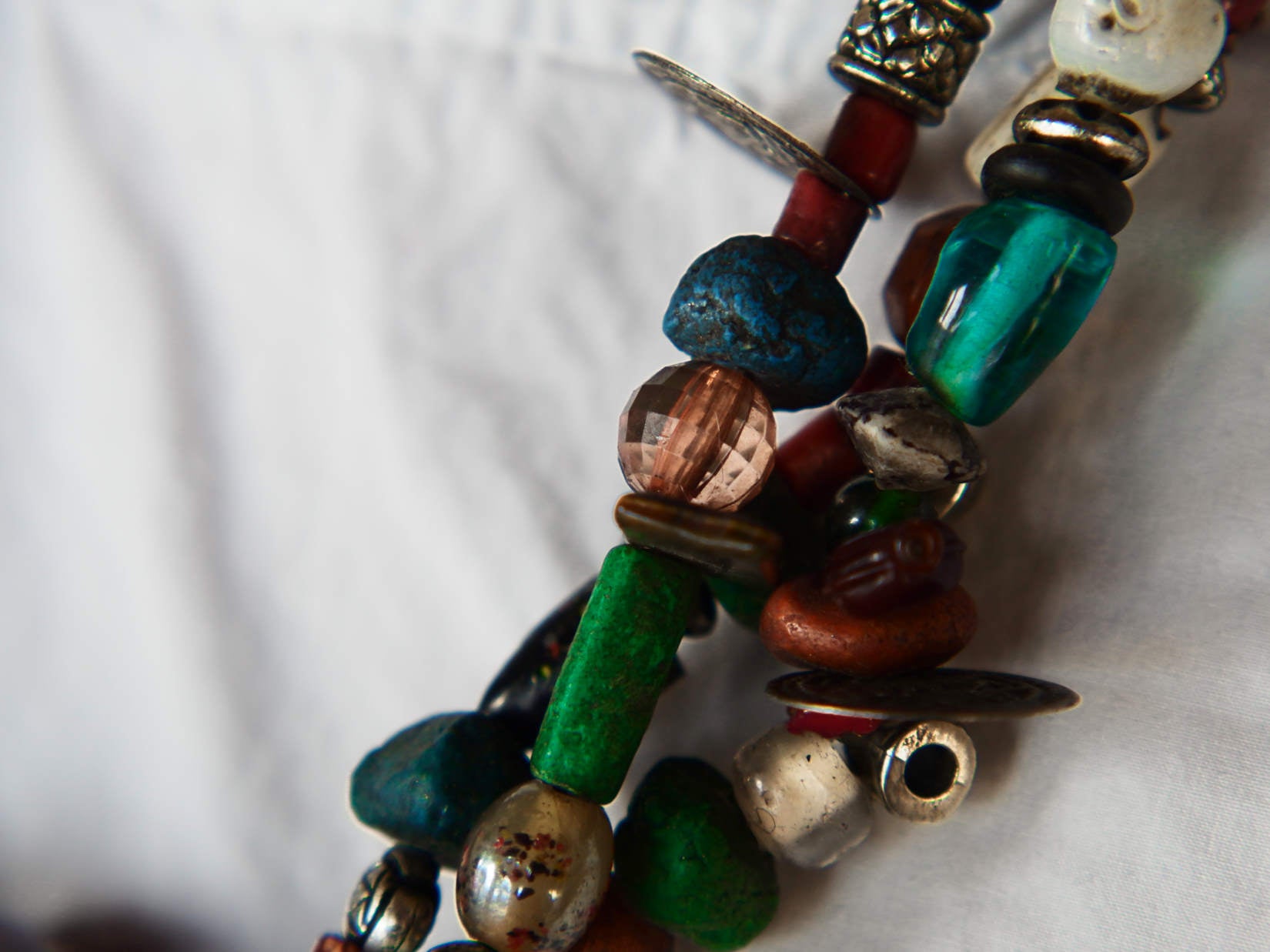 Collana tribale Amazigh, Berbera. Fatta a mano da artigiani berberi tradizionali con perline in ceramica, cristalli, pelle, pietre, corna, resine vegetali naturali e alcune piccole monete vecchie. La pietra centrale di un colore giallo intenso è di diametro 4cm circa, è leggermente ovalizzata. Pezzo unico di origine tribale , disponibili altri modelli oltre a quelli fotografati.  lunghezza 70cm, peso 170 gr