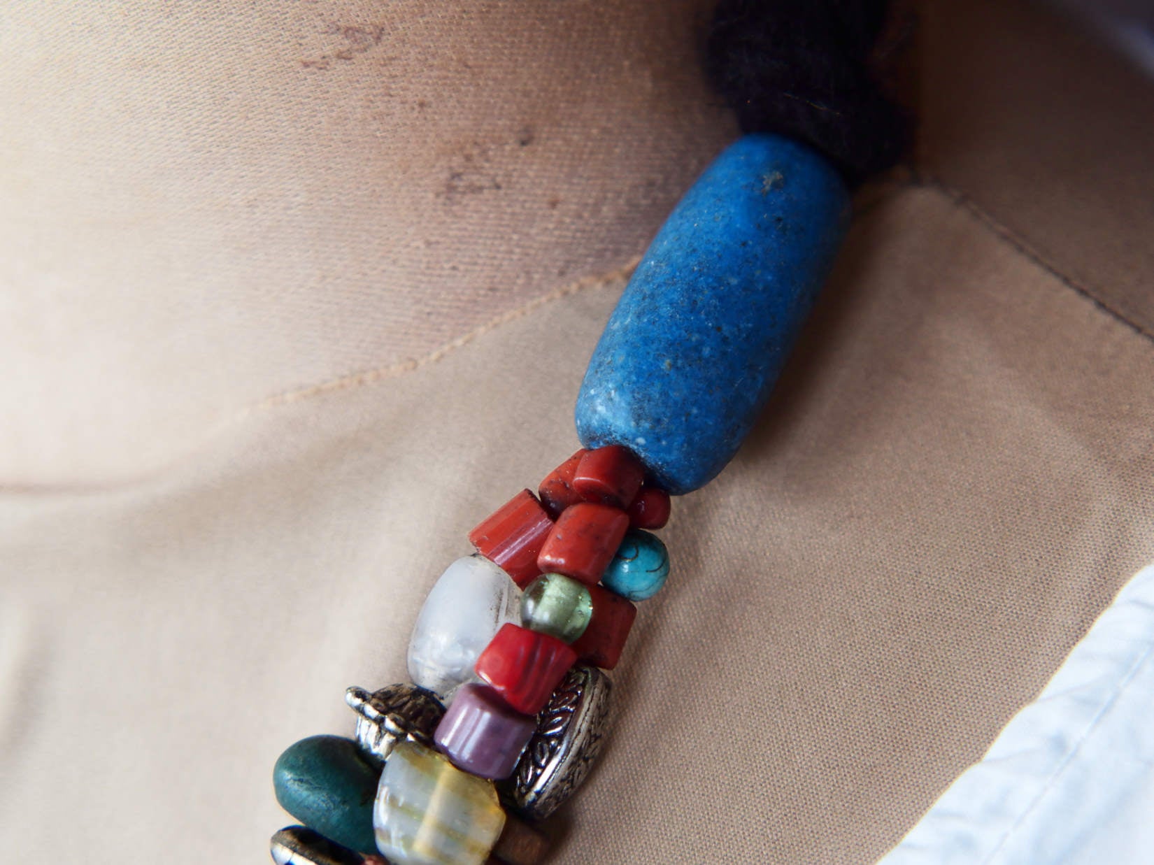Collana tribale Amazigh, Berbera. Fatta a mano da artigiani berberi tradizionali con perline in ceramica, cristalli, pelle, pietre, corna, resine vegetali naturali e alcune piccole monete vecchie. La pietra centrale di un colore giallo intenso è di diametro 4cm circa, è leggermente ovalizzata. Pezzo unico di origine tribale , disponibili altri modelli oltre a quelli fotografati.  lunghezza 70cm, peso 170 gr