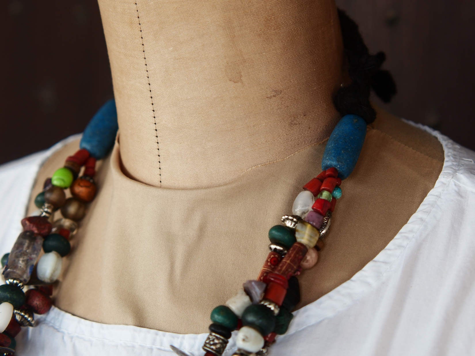 Collana tribale Amazigh, Berbera. Fatta a mano da artigiani berberi tradizionali con perline in ceramica, cristalli, pelle, pietre, corna, resine vegetali naturali e alcune piccole monete vecchie. La pietra centrale di un colore giallo intenso è di diametro 4cm circa, è leggermente ovalizzata. Pezzo unico di origine tribale , disponibili altri modelli oltre a quelli fotografati.  lunghezza 70cm, peso 170 gr