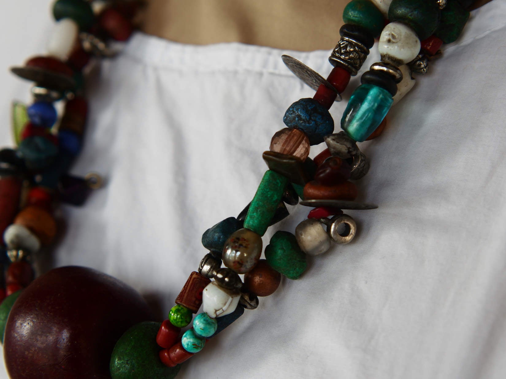 Collana tribale Amazigh, Berbera. Fatta a mano da artigiani berberi tradizionali con perline in ceramica, cristalli, pelle, pietre, corna, resine vegetali naturali e alcune piccole monete vecchie. La pietra centrale di un colore giallo intenso è di diametro 4cm circa, è leggermente ovalizzata. Pezzo unico di origine tribale , disponibili altri modelli oltre a quelli fotografati.  lunghezza 70cm, peso 170 gr