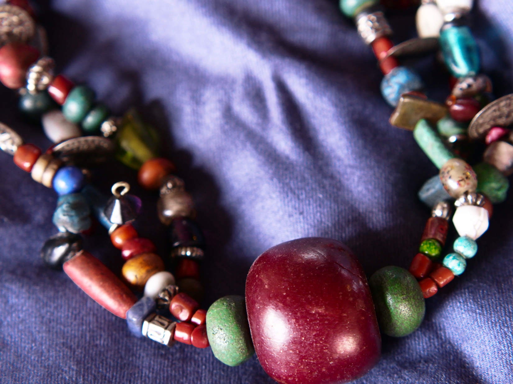 Collana tribale Amazigh, Berbera. Fatta a mano da artigiani berberi tradizionali con perline in ceramica, cristalli, pelle, pietre, corna, resine vegetali naturali e alcune piccole monete vecchie. La pietra centrale di un colore giallo intenso è di diametro 4cm circa, è leggermente ovalizzata. Pezzo unico di origine tribale , disponibili altri modelli oltre a quelli fotografati.  lunghezza 70cm, peso 170 gr