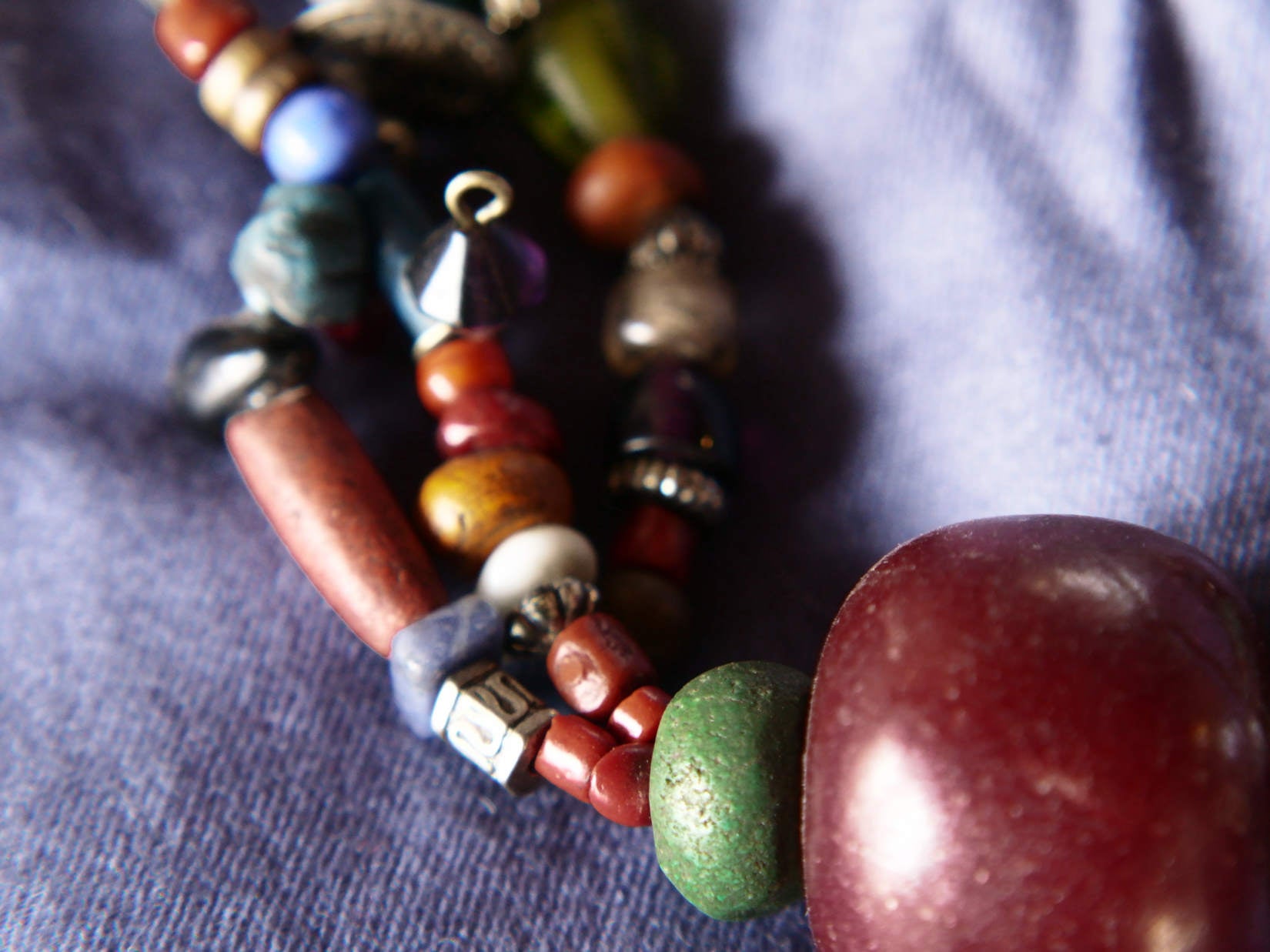 Collana tribale Amazigh, Berbera. Fatta a mano da artigiani berberi tradizionali con perline in ceramica, cristalli, pelle, pietre, corna, resine vegetali naturali e alcune piccole monete vecchie. La pietra centrale di un colore giallo intenso è di diametro 4cm circa, è leggermente ovalizzata. Pezzo unico di origine tribale , disponibili altri modelli oltre a quelli fotografati.  lunghezza 70cm, peso 170 gr