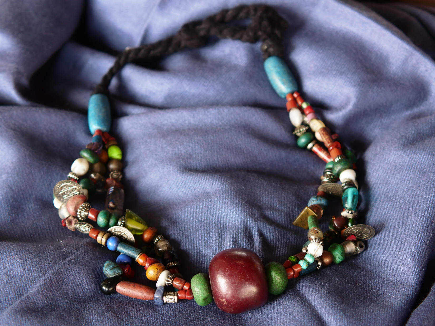 Collana tribale Amazigh, Berbera. Fatta a mano da artigiani berberi tradizionali con perline in ceramica, cristalli, pelle, pietre, corna, resine vegetali naturali e alcune piccole monete vecchie. La pietra centrale di un colore giallo intenso è di diametro 4cm circa, è leggermente ovalizzata. Pezzo unico di origine tribale , disponibili altri modelli oltre a quelli fotografati.  lunghezza 70cm, peso170 gr