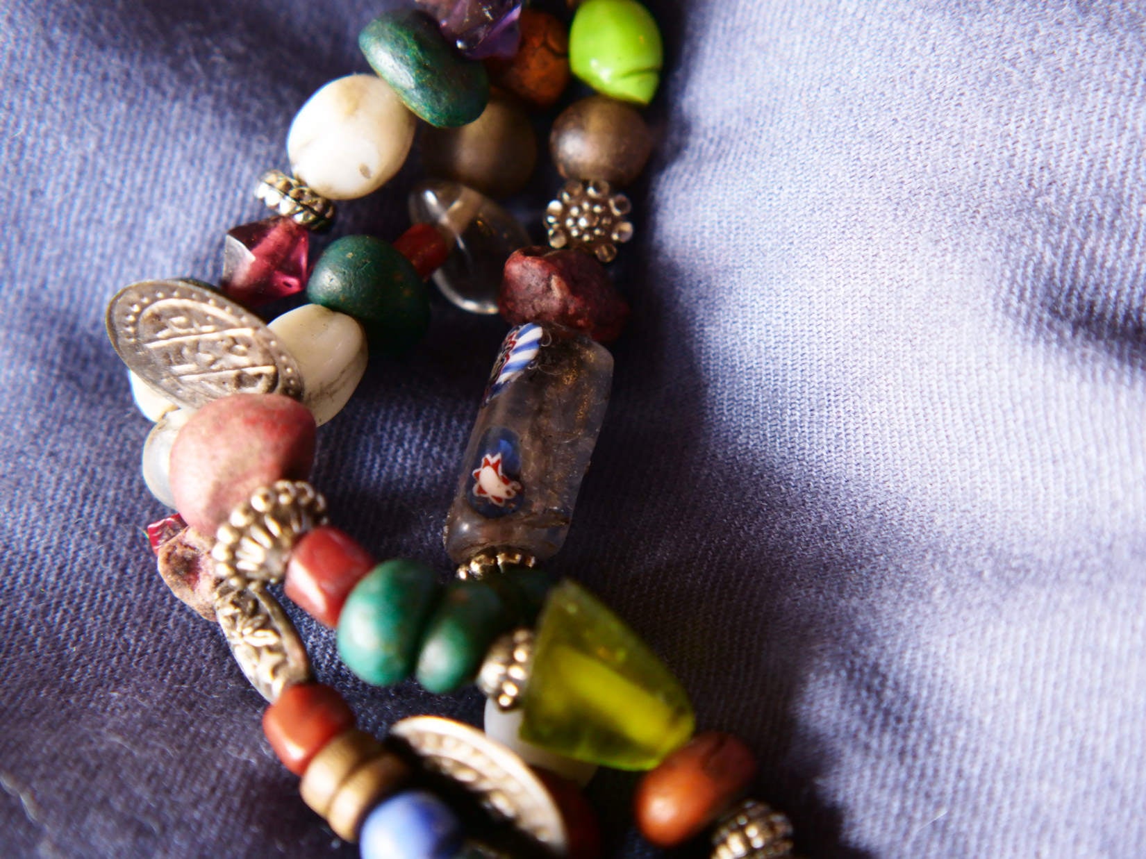 Collana tribale Amazigh, Berbera. Fatta a mano da artigiani berberi tradizionali con perline in ceramica, cristalli, pelle, pietre, corna, resine vegetali naturali e alcune piccole monete vecchie. La pietra centrale di un colore giallo intenso è di diametro 4cm circa, è leggermente ovalizzata. Pezzo unico di origine tribale , disponibili altri modelli oltre a quelli fotografati.  lunghezza 70cm, peso 170 gr