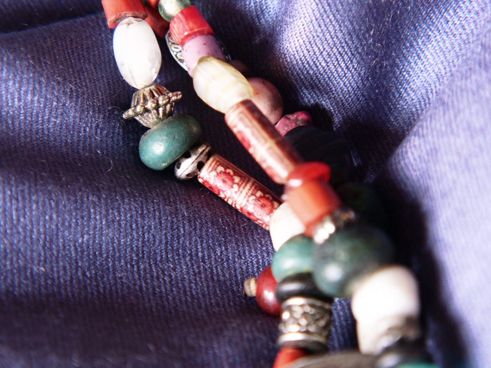 Collana tribale Amazigh, Berbera. Fatta a mano da artigiani berberi tradizionali con perline in ceramica, cristalli, pelle, pietre, corna, resine vegetali naturali e alcune piccole monete vecchie. La pietra centrale di un colore giallo intenso è di diametro 4cm circa, è leggermente ovalizzata. Pezzo unico di origine tribale , disponibili altri modelli oltre a quelli fotografati.  lunghezza 70cm, peso 170 gr