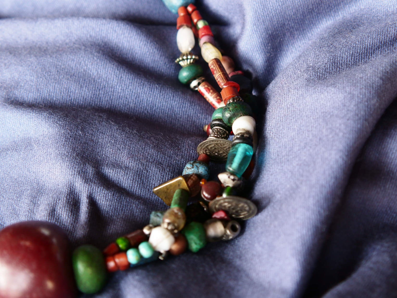 Collana tribale Amazigh, Berbera. Fatta a mano da artigiani berberi tradizionali con perline in ceramica, cristalli, pelle, pietre, corna, resine vegetali naturali e alcune piccole monete vecchie. La pietra centrale di un colore giallo intenso è di diametro 4cm circa, è leggermente ovalizzata. Pezzo unico di origine tribale , disponibili altri modelli oltre a quelli fotografati.  lunghezza 70cm, peso 170 gr