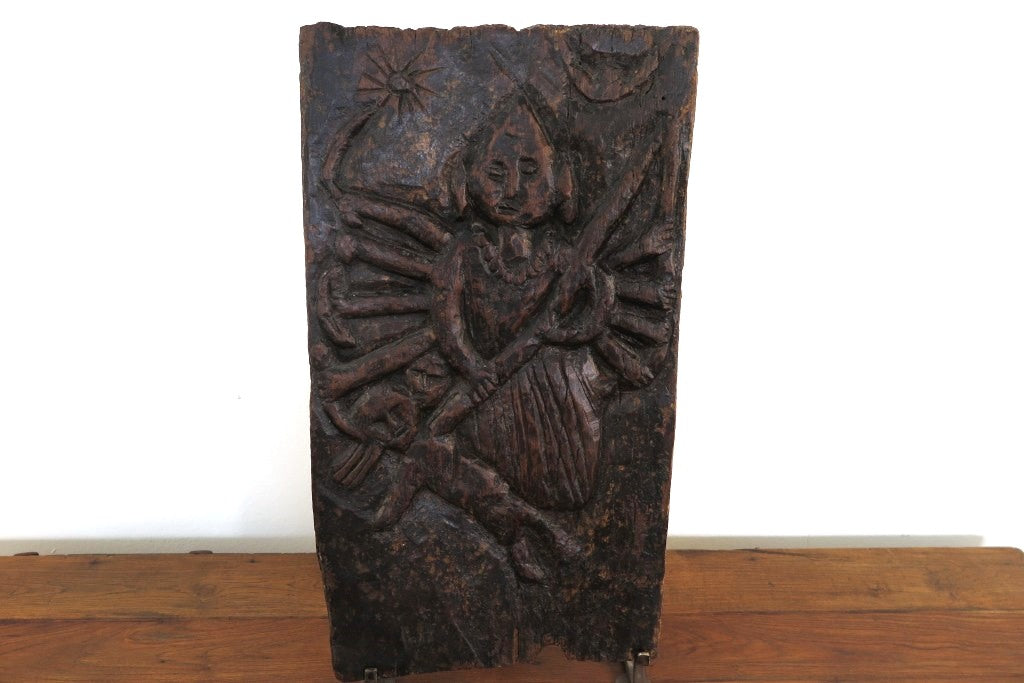antico pannello inciso in legno di teak databile primi '900 raffigurante Kalì, una divinità femminile hindu, descritta come battagliera e feroce, spesso associata al dio Siva del quale, in alcuni testi, incarna gli aspetti complementari. In alcune tradizioni tantriche Kālī è adorata come realtà ultima, dea al contempo personale e impersonale, al di sopra di ogni altra divinità e manifestazione del cosmo.  dotata di basamento. dimensioni 29x56xprof19cm.