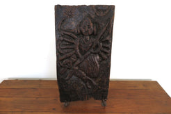 antico pannello inciso in legno di teak databile primi '900 raffigurante Kalì, una divinità femminile hindu, descritta come battagliera e feroce, spesso associata al dio Siva del quale, in alcuni testi, incarna gli aspetti complementari. In alcune tradizioni tantriche Kālī è adorata come realtà ultima, dea al contempo personale e impersonale, al di sopra di ogni altra divinità e manifestazione del cosmo.  dotata di basamento. dimensioni 29x56xprof19cm.