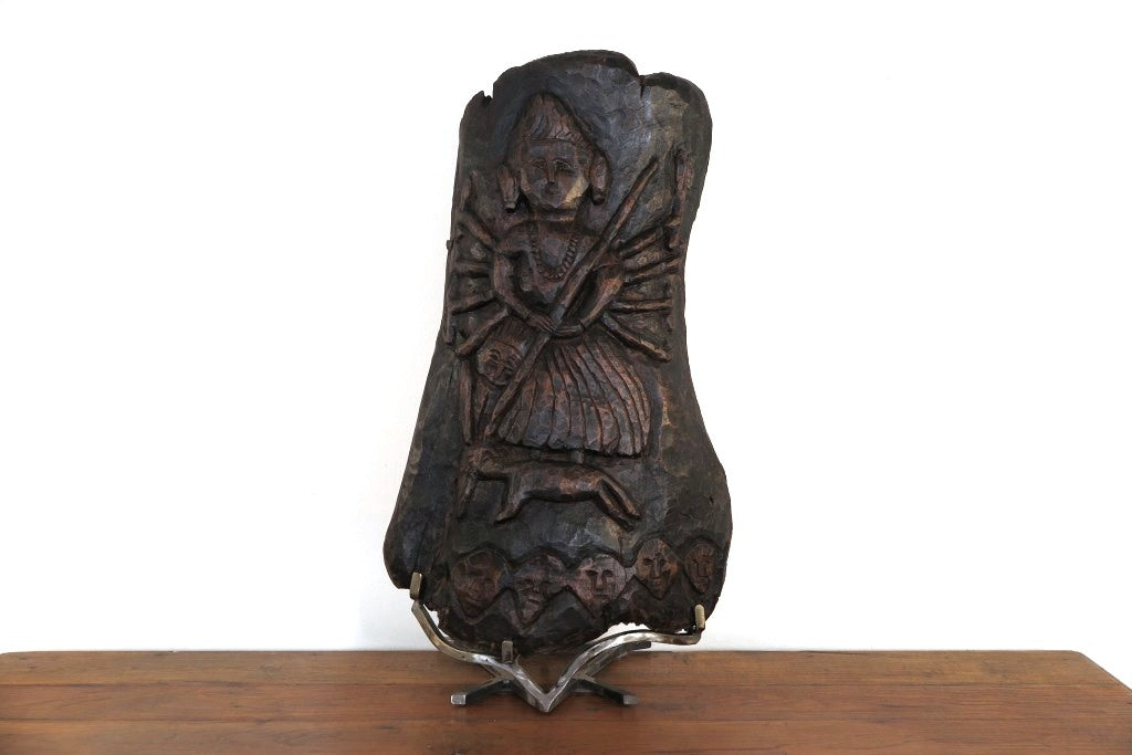 antico pannello inciso in legno di teak databile fine '800 raffigurante Kalì, una divinità femminile hindu, descritta come battagliera e feroce, spesso associata al dio Siva del quale, in alcuni testi, incarna gli aspetti complementari. In alcune tradizioni tantriche Kālī è adorata come realtà ultima, dea al contempo personale e impersonale, al di sopra di ogni altra divinità e manifestazione del cosmo.  dotata di basamento. dimensioni 35x66xprof.22cm