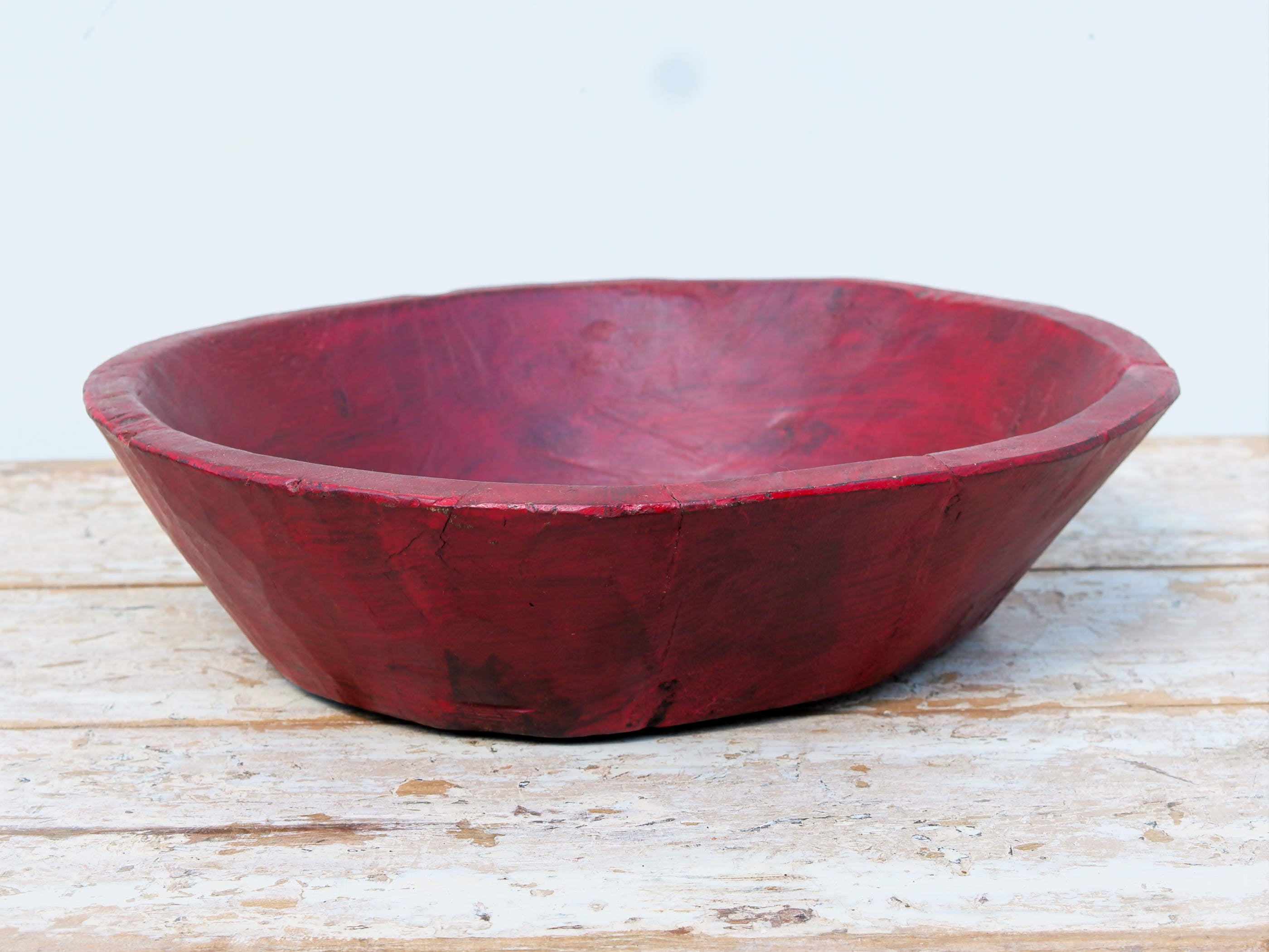 piatto in legno dipinto rosso ricavato da un unico tronco di legno. usato in principio come piatto , setaccio per esiccare i cereali . tronco unico di teak massello databile inizio / metà 900 .  dimensioni diametro 35 h9cm.   disponibili vari modelli , contattare per info ed ulteriori foto info@etniko.it 0039 3338778241 fb/ig : etnikobycrosato