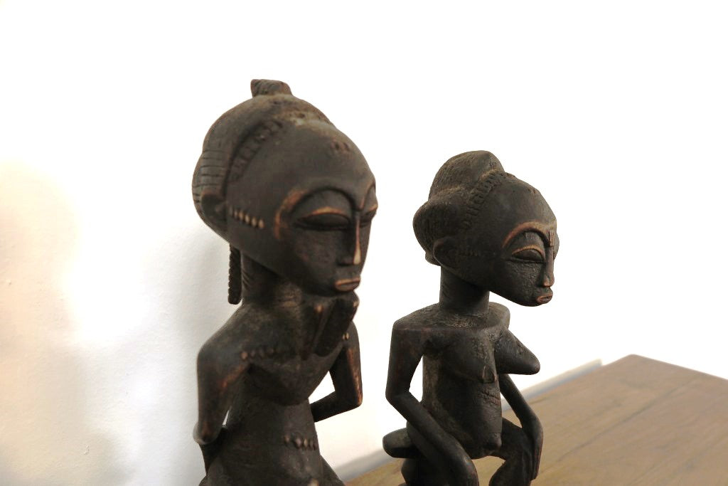 statua in legno originaria della Costa d’ Avorio databile seconda metà 900 .  Il popolo Baulè è il più grande gruppo etnico in questo stato .  La scultura dei Baule è completamente differente dagli altri popoli Akan, non è tramandata ma frutto della volontà dello scultore. Le statue Baule sono generalmente in piedi con le gambe leggermente piegate, con le mani appoggiate sul loro addome in sego di pace, e il collo allungato a sostegno di un volto con scarificazione tipicamente rialzato e occhi sporgenti. La