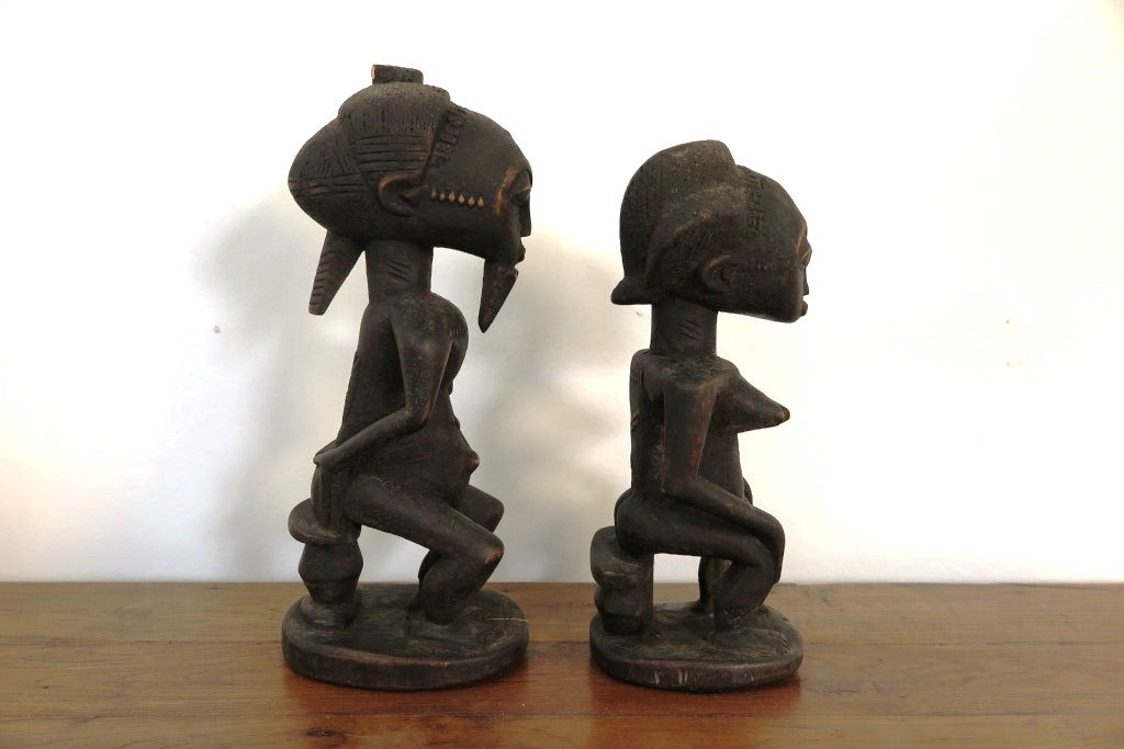 statua in legno originaria della Costa d’ Avorio databile seconda metà 900 .  Il popolo Baulè è il più grande gruppo etnico in questo stato .  La scultura dei Baule è completamente differente dagli altri popoli Akan, non è tramandata ma frutto della volontà dello scultore. Le statue Baule sono generalmente in piedi con le gambe leggermente piegate, con le mani appoggiate sul loro addome in sego di pace, e il collo allungato a sostegno di un volto con scarificazione tipicamente rialzato e occhi sporgenti. La