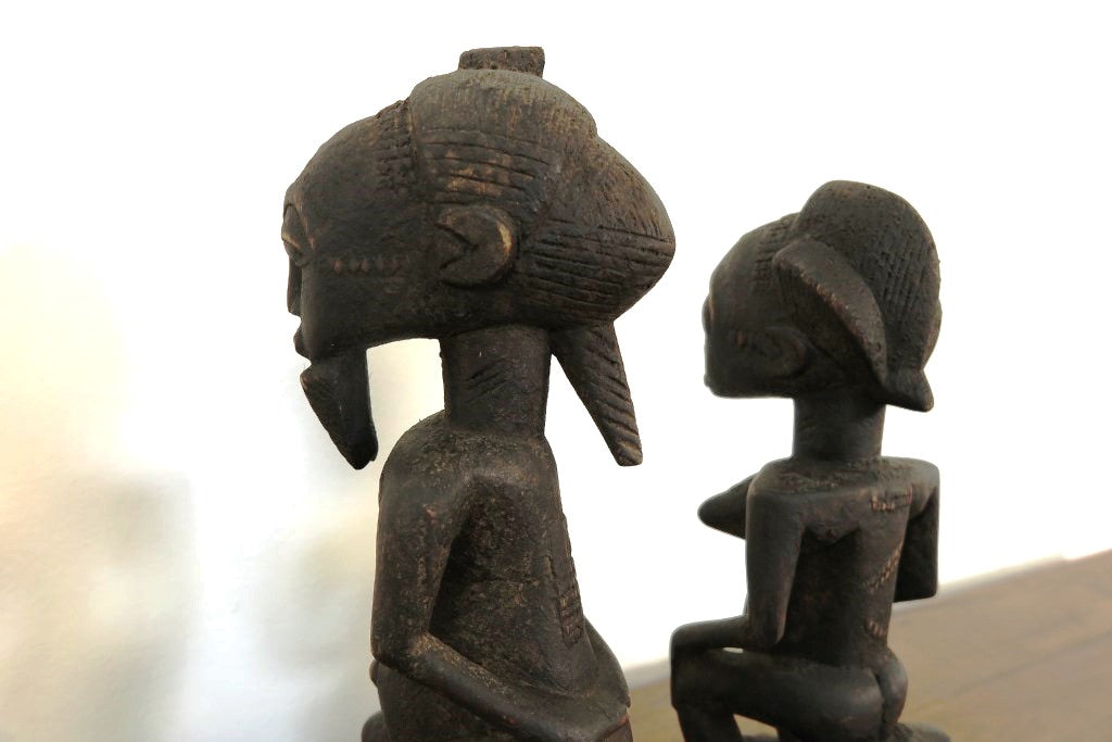 statua in legno originaria della Costa d’ Avorio databile seconda metà 900 .  Il popolo Baulè è il più grande gruppo etnico in questo stato .  La scultura dei Baule è completamente differente dagli altri popoli Akan, non è tramandata ma frutto della volontà dello scultore. Le statue Baule sono generalmente in piedi con le gambe leggermente piegate, con le mani appoggiate sul loro addome in sego di pace, e il collo allungato a sostegno di un volto con scarificazione tipicamente rialzato e occhi sporgenti. La