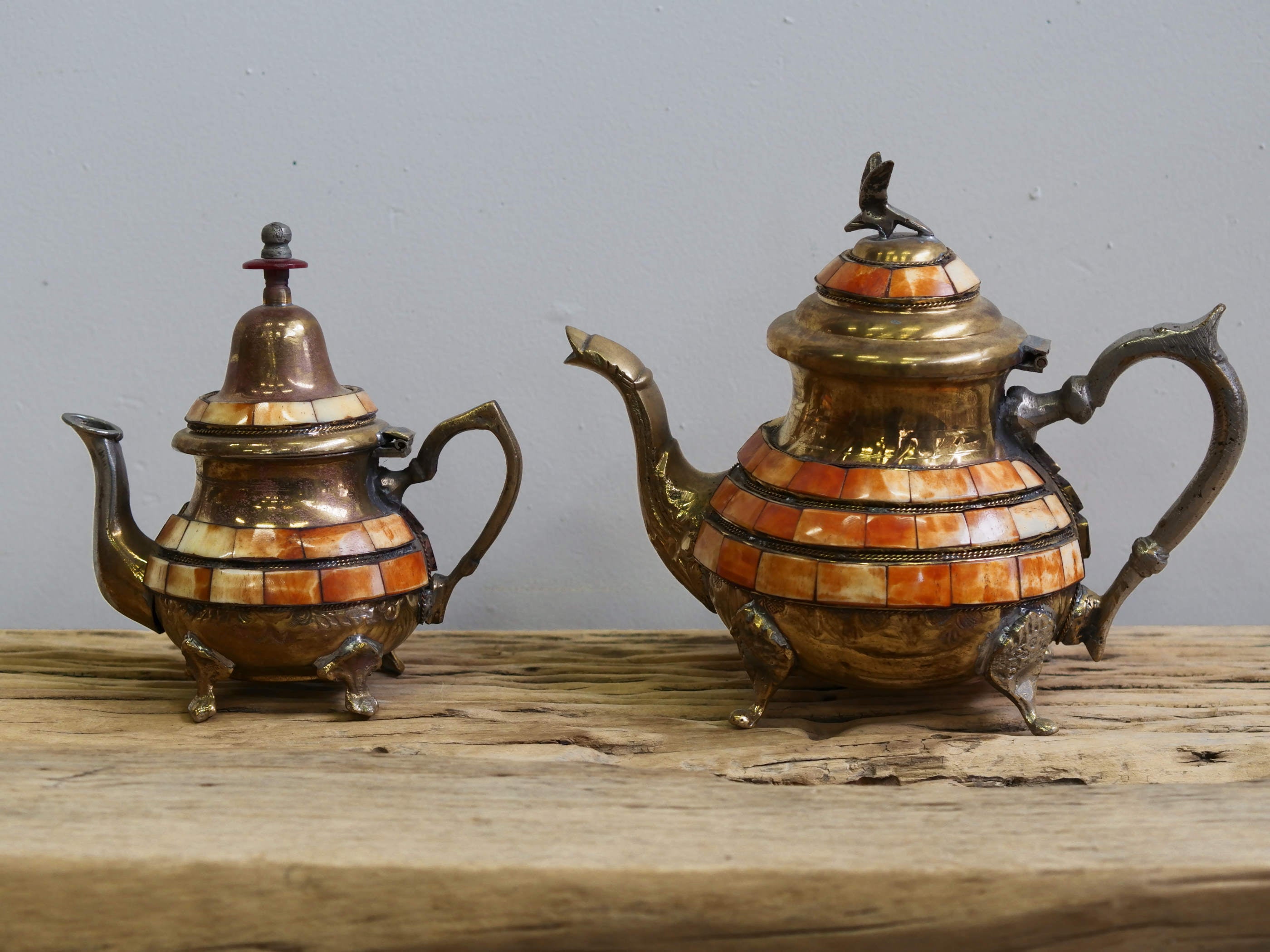 Coppia teiere berbere tribali vintage in ottone con inserti in osso di cammello dipinti. Cesellate e lavorate interamente a mano artigianalmente, perfettamente conservate. Parte superiore apribile.  pezzi unici come da foto.  su richiesta possiamo spedire anche singolarmente  teiera piccola euro 30, teiera grande euro 50, la coppia scontata euro 60  Dimensioni 23x13xh20cm, 16x10xh17cm. 