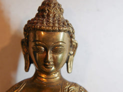 il Buddha è raffigurato con le gambe incrociate, i piedi posizionati allo stesso livello, con la pianta rivolta verso l’alto.