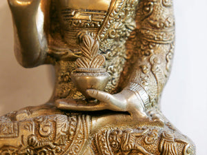 il Buddha è raffigurato con le gambe incrociate, i piedi posizionati allo stesso livello, con la pianta rivolta verso l’alto.