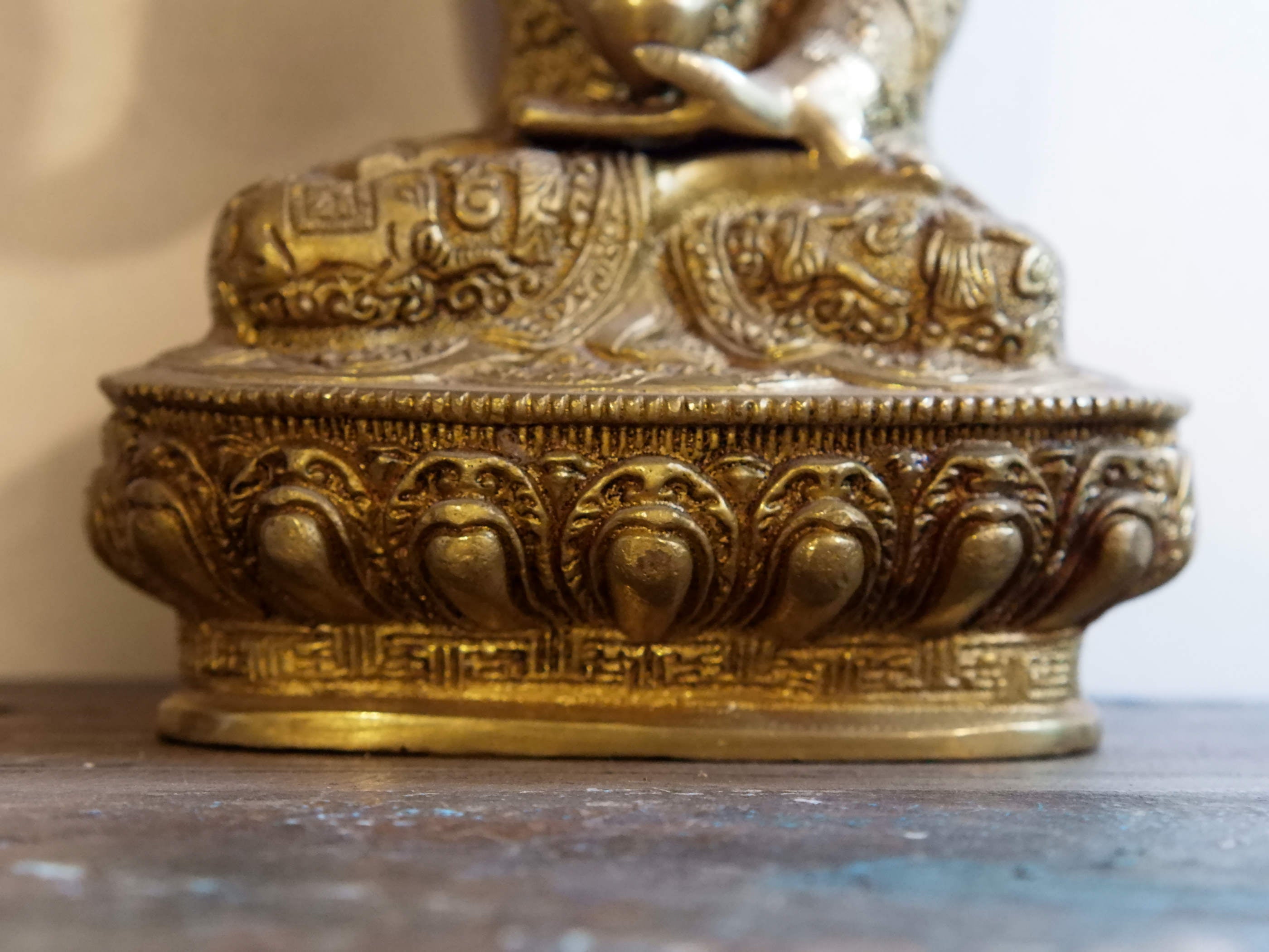il Buddha è raffigurato con le gambe incrociate, i piedi posizionati allo stesso livello, con la pianta rivolta verso l’alto.