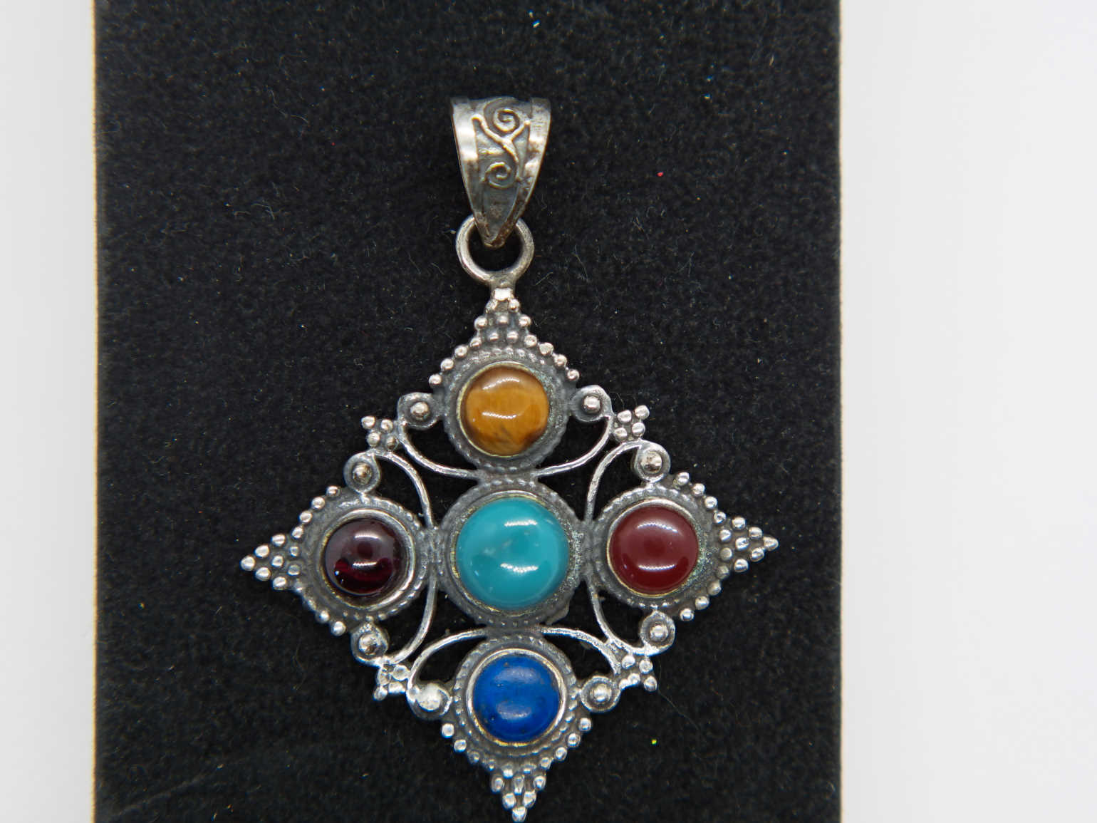 pendaglio tibetano / nepalese in argento 800 con turchese , lapislazzulo ,corniola , granato e occhio di tigre  pezzo unico lavorato artigianalmente tutto originale ed autentico .   peso 15gr  dimensioni 4,3x4,3 cm