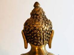 il Buddha è raffigurato con le gambe incrociate, i piedi posizionati allo stesso livello, con la pianta rivolta verso l’alto.