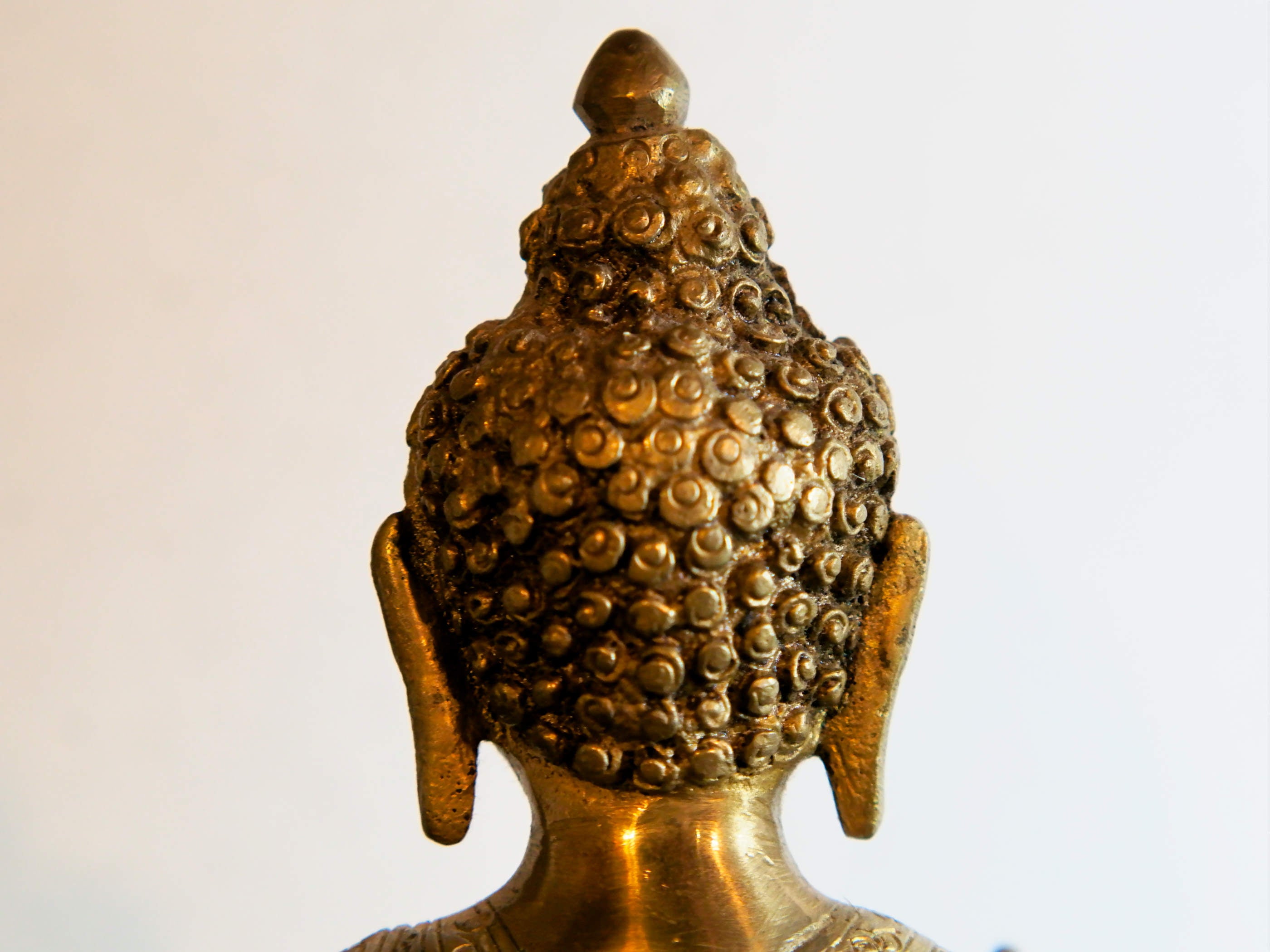 il Buddha è raffigurato con le gambe incrociate, i piedi posizionati allo stesso livello, con la pianta rivolta verso l’alto.