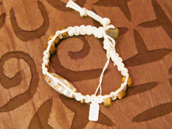 bracciale intrecciato con dzi in agata , chiusura a bottone regolabile in misura.  lunghezza totale 24 cm  dimensioni dzi 3x1 cm La nostra collezione di Dzi è composta da pezzi antichi e pezzi di più recente realizzazione, tutti comunque provenienti dal Tibet e realizzati secondo le antiche tradizioni.La pietra di base è sempre un’agata che viene incisa con simboli circolari, ovali, quadrati o a strisce che vanno a formare i così detti “occhi”.