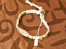 Carica l&#39;immagine nel visualizzatore di Gallery, bracciale intrecciato con dzi in agata , chiusura a bottone regolabile in misura.  lunghezza totale 24 cm  dimensioni dzi 3x1 cm La nostra collezione di Dzi è composta da pezzi antichi e pezzi di più recente realizzazione, tutti comunque provenienti dal Tibet e realizzati secondo le antiche tradizioni.La pietra di base è sempre un’agata che viene incisa con simboli circolari, ovali, quadrati o a strisce che vanno a formare i così detti “occhi”.