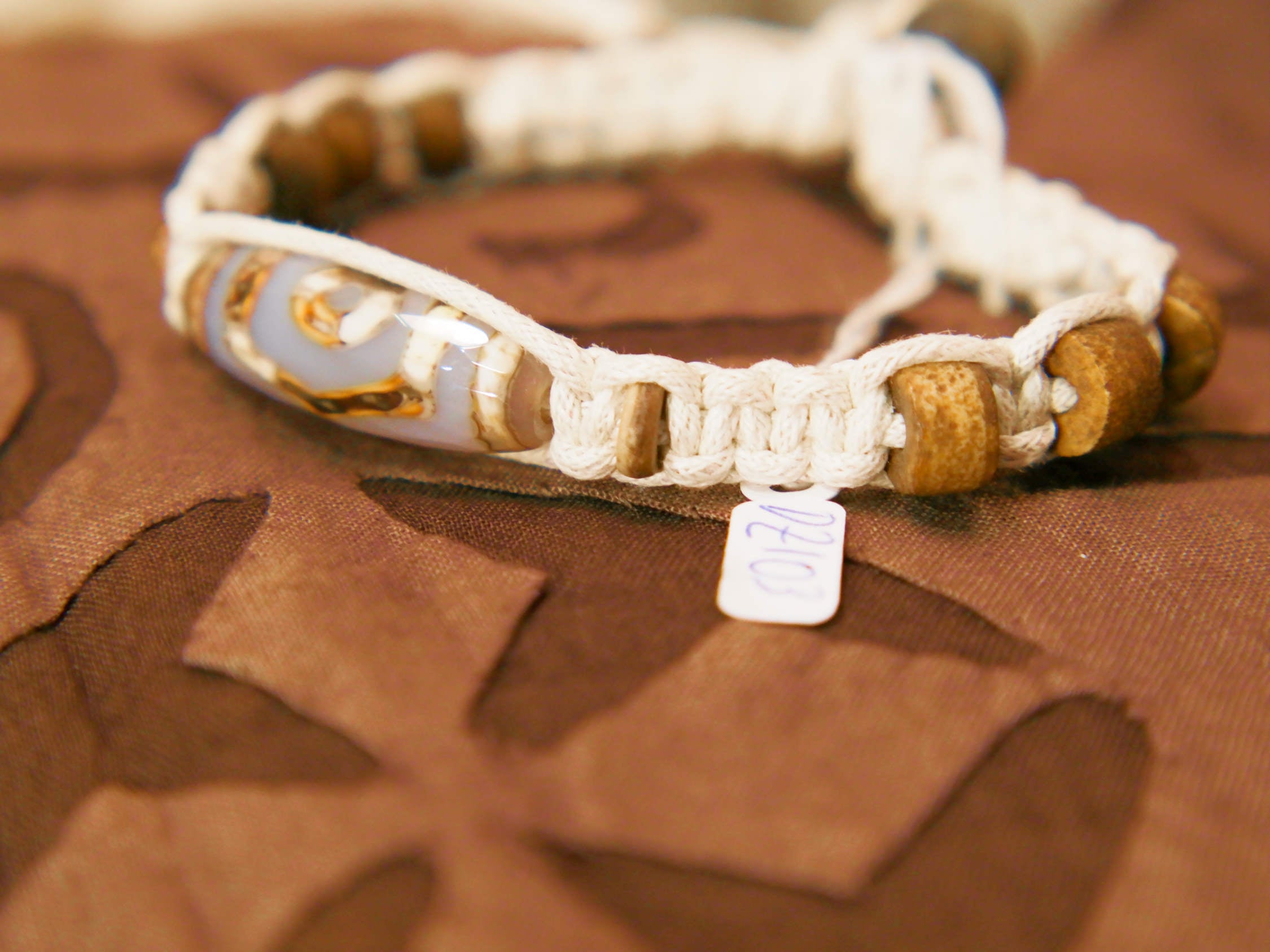 bracciale intrecciato con dzi in agata , chiusura a bottone regolabile in misura.  lunghezza totale 24 cm  dimensioni dzi 3x1 cm La nostra collezione di Dzi è composta da pezzi antichi e pezzi di più recente realizzazione, tutti comunque provenienti dal Tibet e realizzati secondo le antiche tradizioni.La pietra di base è sempre un’agata che viene incisa con simboli circolari, ovali, quadrati o a strisce che vanno a formare i così detti “occhi”.
