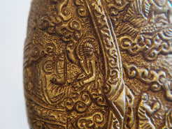 il Buddha è raffigurato con le gambe incrociate, i piedi posizionati allo stesso livello, con la pianta rivolta verso l’alto.