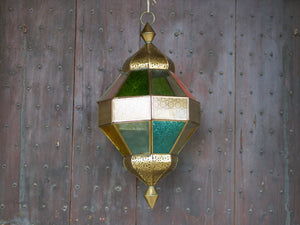 Lanterna indiana in metallo lavorata artigianalmente, finemente decorata a traforo, con vetro multicolor e trasparente.  Disponibile anche nella versione con solo vetro trasparente. Con piccolo portacandele interno e gancio per appendere .    dimensioni diametro 25  h55  per info ed ulteriori foto info@etniko.it facebook / instagram / pinterest : etnikobycrosato 0039 3338778241