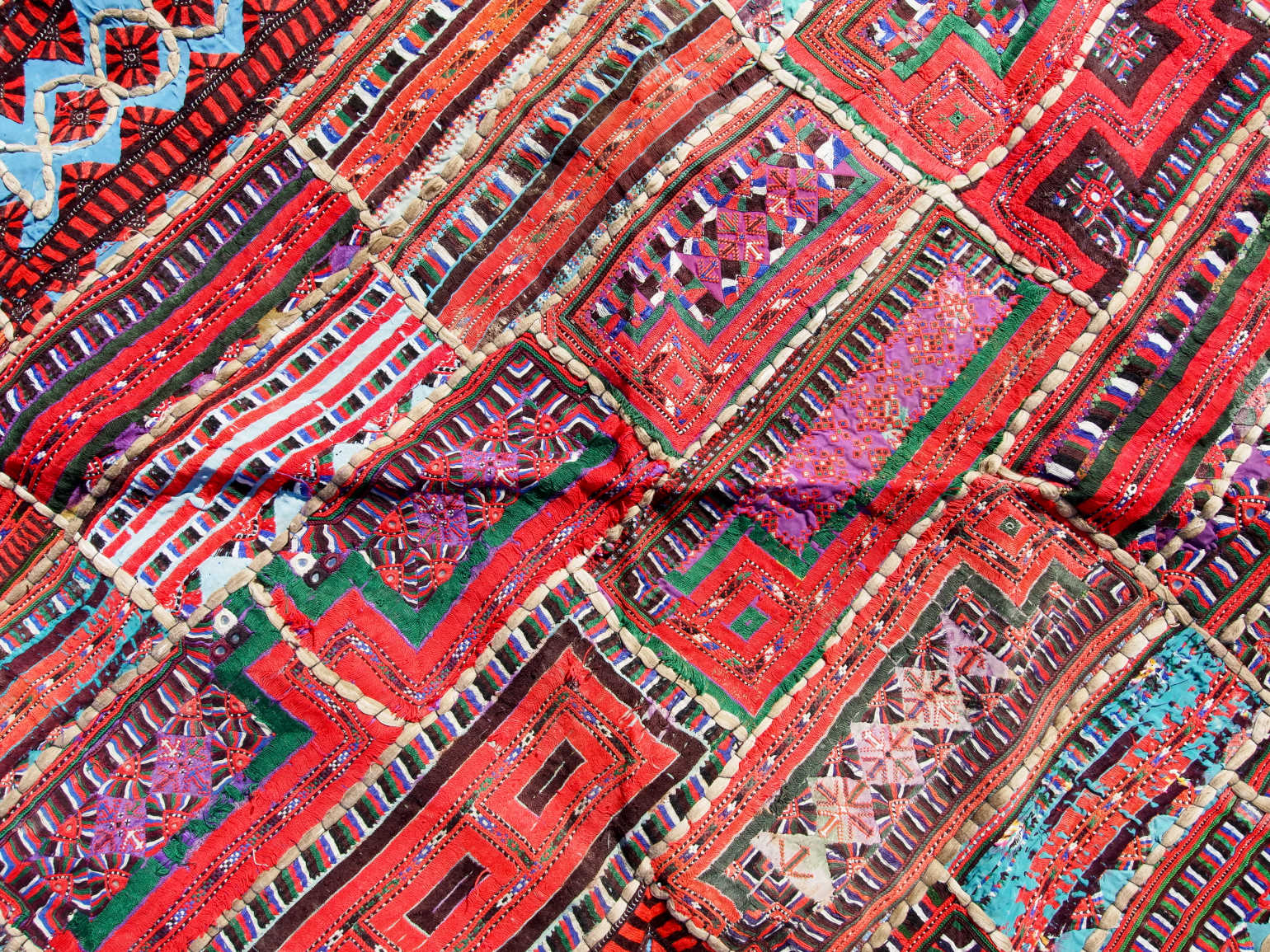 vecchio arazzo in cotone, lavorato artigianalmente a mano con tecnica patchwork.  per ogni pezzo ci possono volere mesi di lavoro sia per i ricami che per la ricerca di elementi, pezzi di tessuto antico, da abbinare all'arazzo.  tipici dell'india del nord, in Rajasthan  l'arazzo in casa è simbolo di fortuna e prosperità.  Pezzo Unico. Ideale come tessuto da appendere a parete ma si puo' impiegare anche come tappeto.    Dimensioni 100x180cm