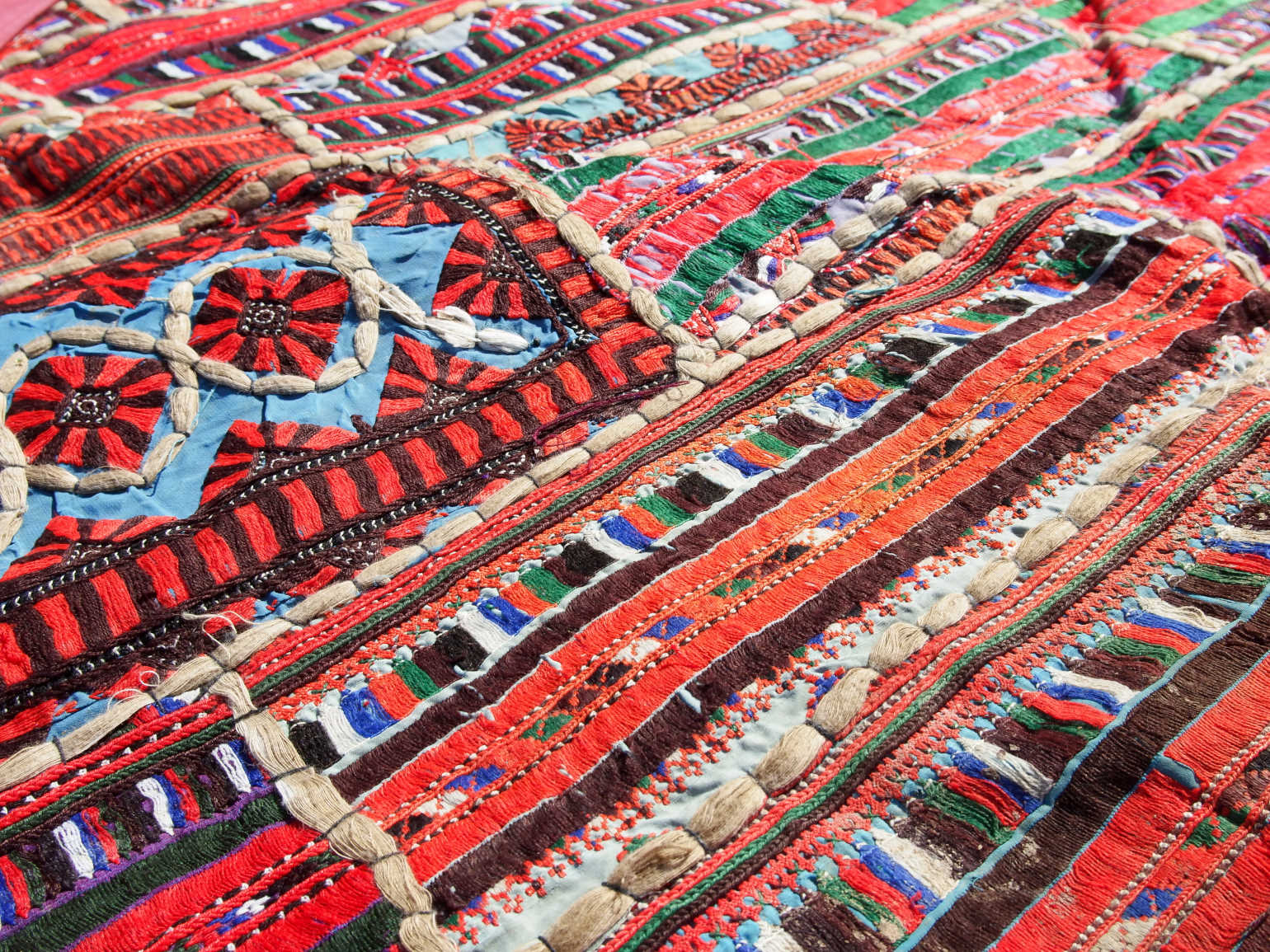vecchio arazzo in cotone, lavorato artigianalmente a mano con tecnica patchwork.  per ogni pezzo ci possono volere mesi di lavoro sia per i ricami che per la ricerca di elementi, pezzi di tessuto antico, da abbinare all'arazzo.  tipici dell'india del nord, in Rajasthan  l'arazzo in casa è simbolo di fortuna e prosperità.  Pezzo Unico. Ideale come tessuto da appendere a parete ma si puo' impiegare anche come tappeto.    Dimensioni 100x180cm
