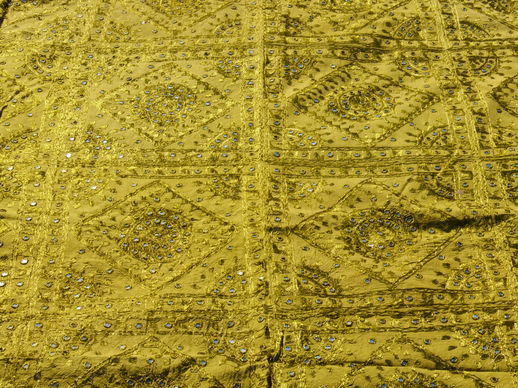 Telo Indiano in cotone doppio strato, ricamato tono su tono con specchietti,  di color verde. Può essere impiegato come copridivano, copriletto, tovaglia o tessuto da appendere a parete. Dimensioni 230x260cm