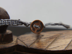 bracciale intrecciato con dzi in agata , chiusura a bottone regolabile in misura.