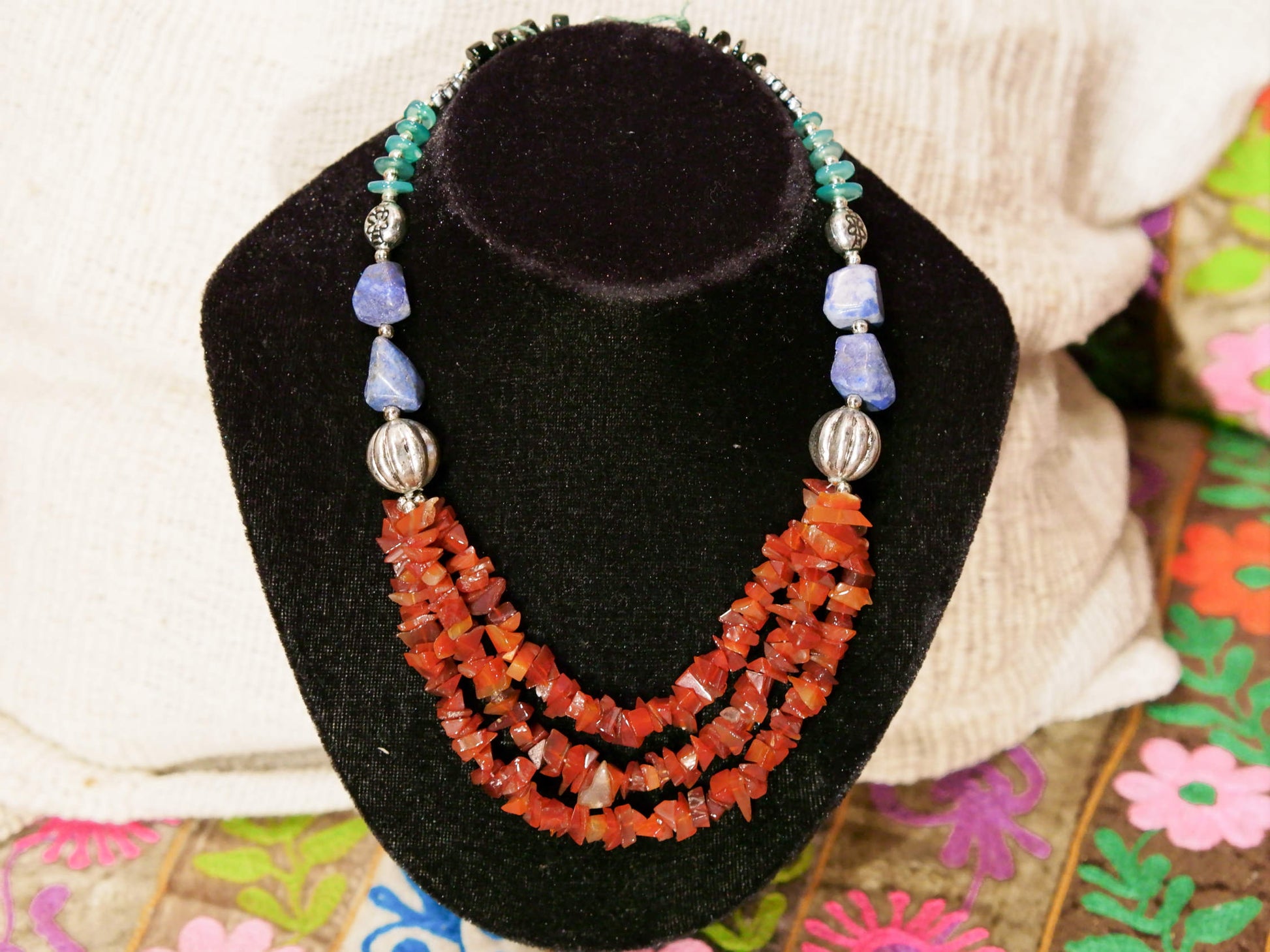 collana con pietre semipreziose , pietre dure .  pietre naturali non tinte o alterate chimicamente , corniola , lapis , onice , giada . Pezzo unico assembrato artigianalmente .  lunghezza 44 cm  peso 65 gr 