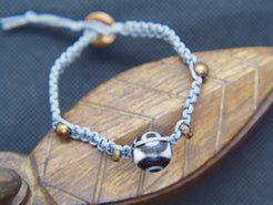 bracciale intrecciato con dzi in agata , chiusura a bottone regolabile in misura.