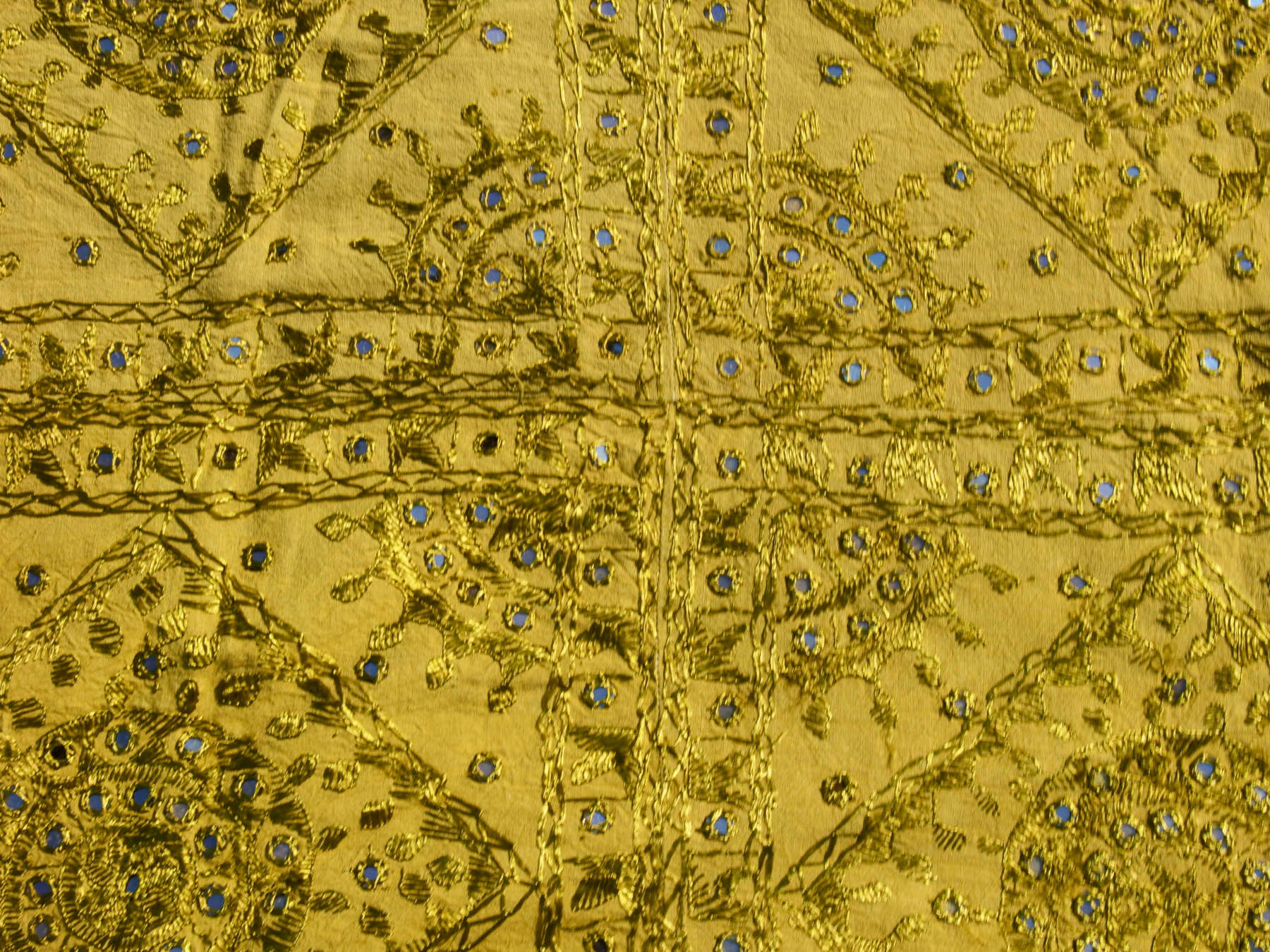 Telo Indiano in cotone doppio strato, ricamato tono su tono con specchietti,  di color verde. Può essere impiegato come copridivano, copriletto, tovaglia o tessuto da appendere a parete. Dimensioni 230x260cm