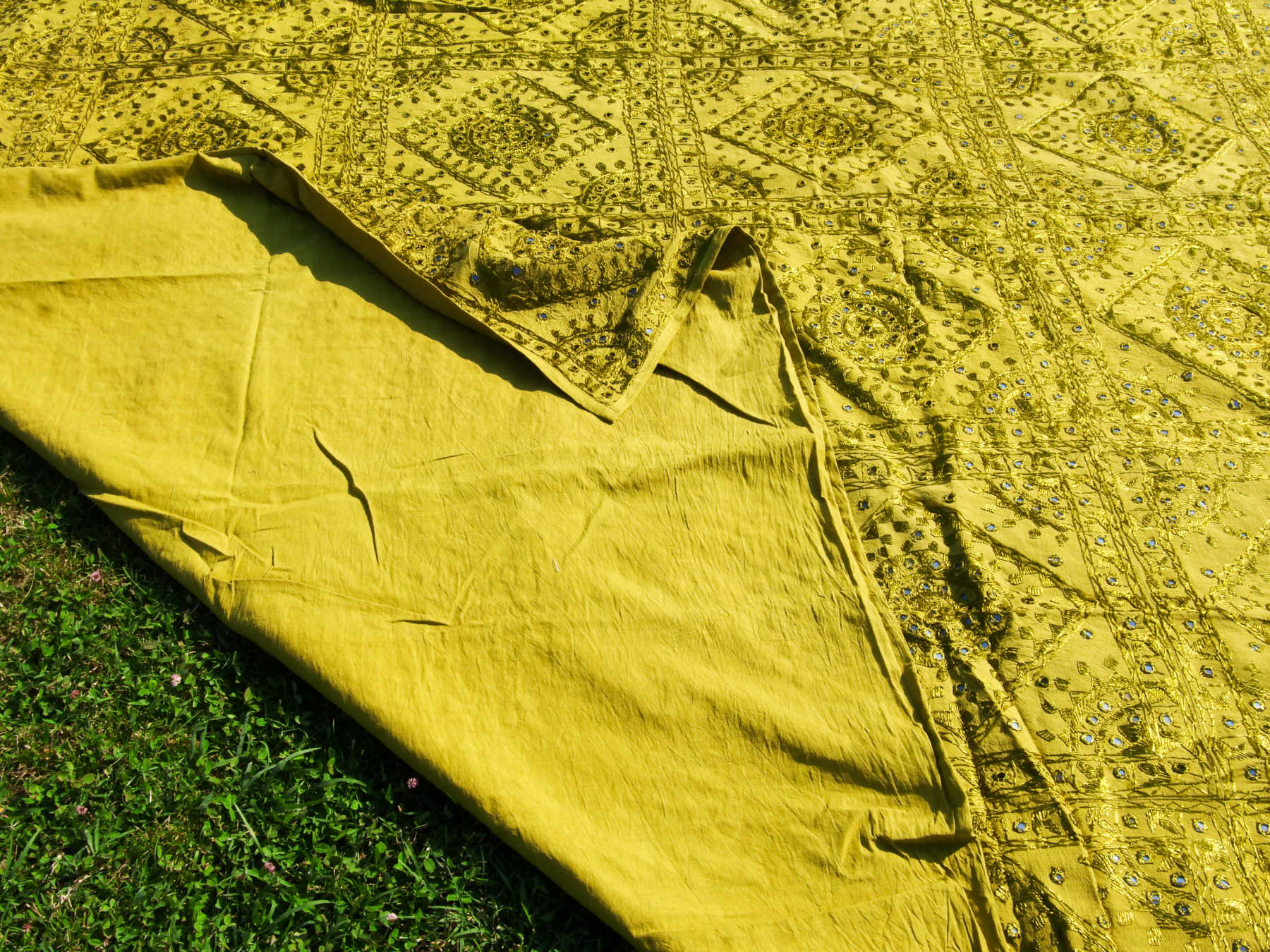 Telo Indiano in cotone doppio strato, ricamato tono su tono con specchietti,  di color verde. Può essere impiegato come copridivano, copriletto, tovaglia o tessuto da appendere a parete. Dimensioni 230x260cm