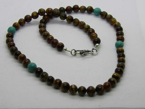collana monofilo con occhio di tigre intervallata da turchesi  pietre semipreziose naturali di alta qualità , non tinte o caricate di colore .  su richiesta disponibili altri modelli o si possono infilare con i colori e pietre disponibili , contattare per info e dettagli .   diamentro perle 6 mm 