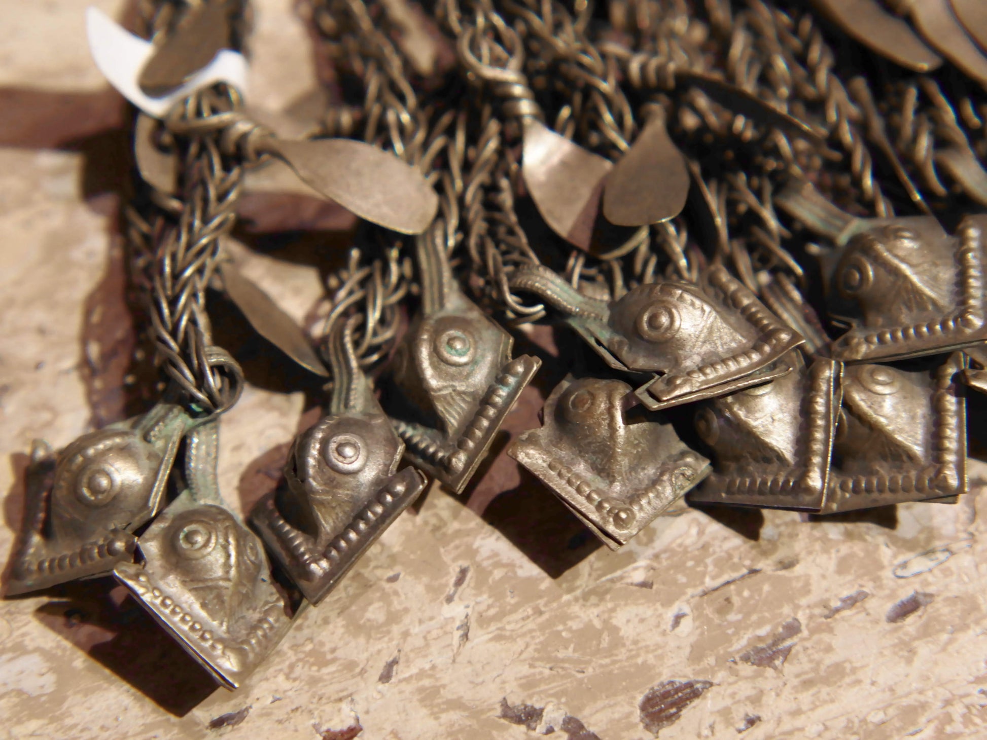 La sezione superiore ha applicate sette ganci decorativi con finale rotondo .  La scatola si apre ad un'estremità e ha un cilindro di rame argento per l'inserimento di oggetti protettivi magici e "mantra".( questo taviz è stato sigillato in modo da non perdere parte dell'oggetto )