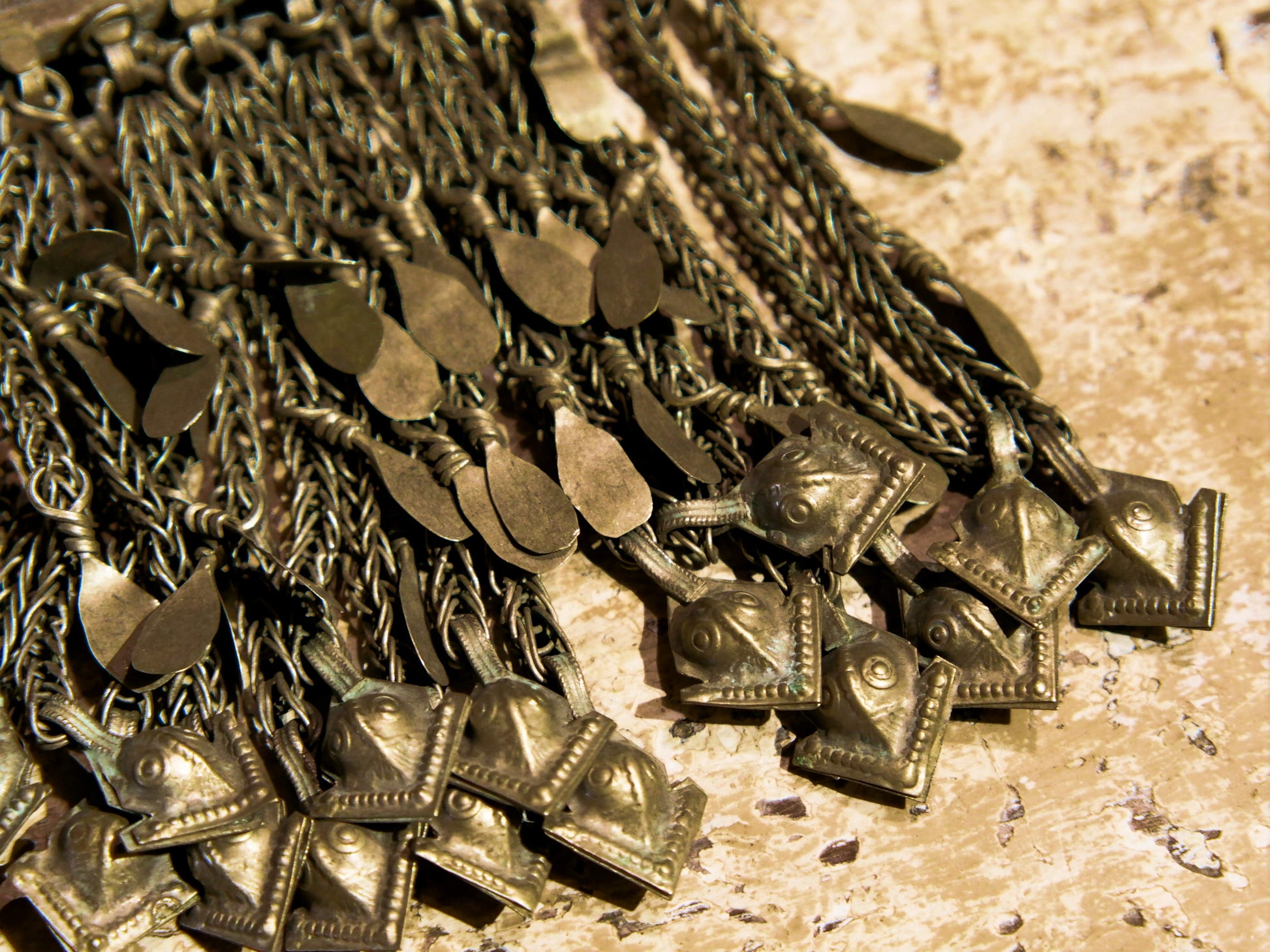 La sezione superiore ha applicate sette ganci decorativi con finale rotondo .  La scatola si apre ad un'estremità e ha un cilindro di rame argento per l'inserimento di oggetti protettivi magici e "mantra".( questo taviz è stato sigillato in modo da non perdere parte dell'oggetto )