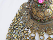 Carica l&#39;immagine nel visualizzatore di Gallery, Questa lunga e massiccia collana proviene probabilmente da una delle tribù nomadi dell&#39;Afghanistan o del Turkmenistan. Il ciondolo ha inscritto motivi floreali e boteh (paisley). Costruito in lega di argento, pezzo unico databile primi 900, conservato perfettamente, le catene che all&#39;estremità hanno una sfera campanellino sono originali e incastrate a mano. Pezzo di difficile reperibilità.  lunghezza totale 20 cm, diametro parte superiore 10 cm, peso 170 gr