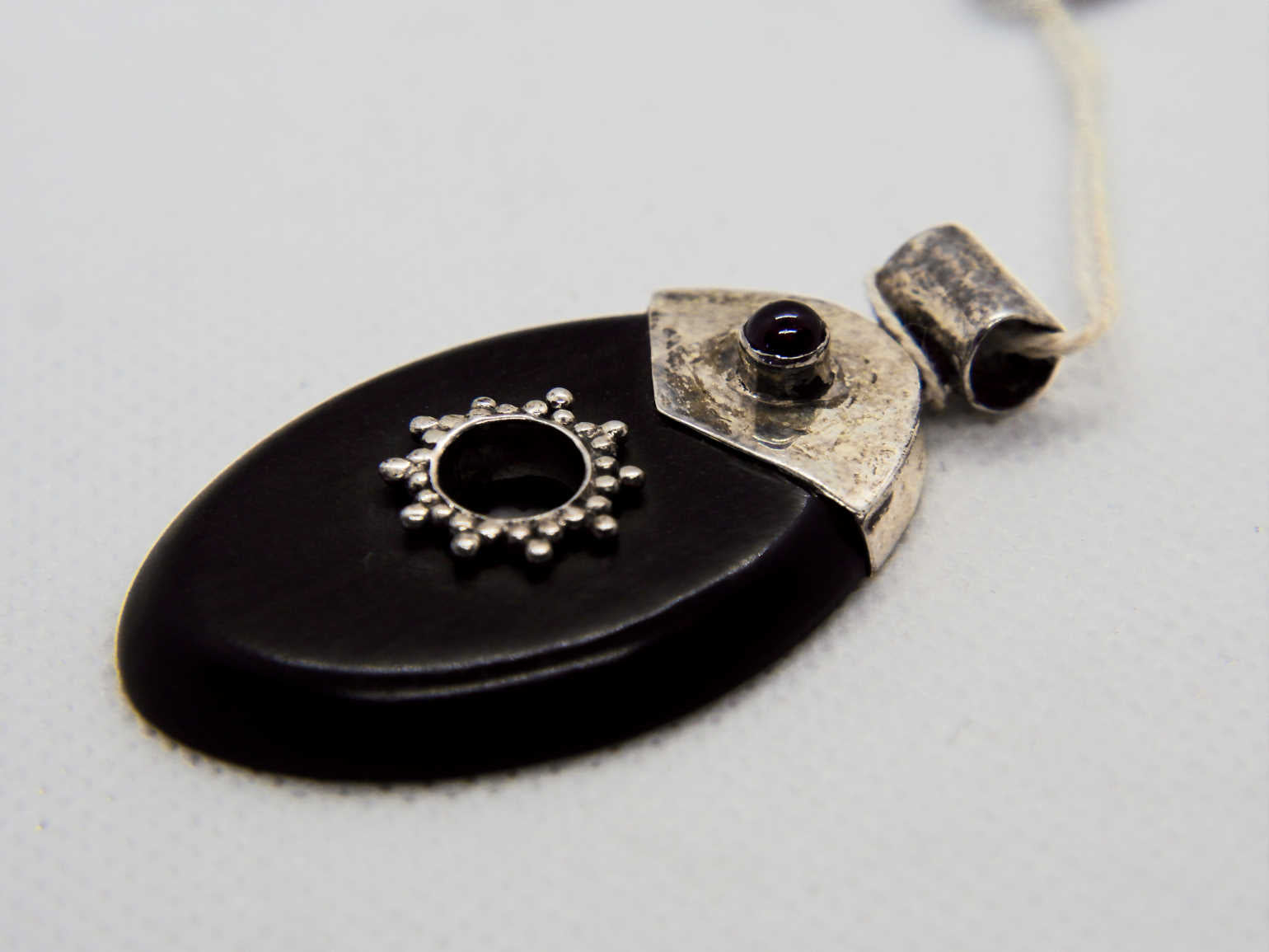 pendaglio in ebano nero intagliato a foglia con punto in granato  dimensione 5,5 x 3 cm  peso 8,3 gr 