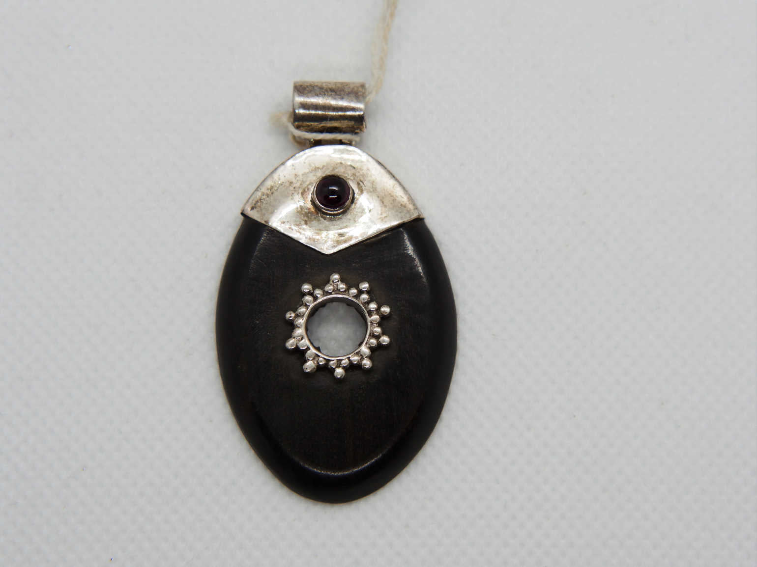 pendaglio in ebano nero intagliato a foglia con punto in granato  dimensione 5,5 x 3 cm  peso 8,3 gr 