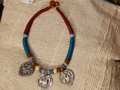collana in cotone intrecciato con vecchi  pendaglii  raffigurantetipiche figure tribali dell'india del nord .  misure collana 44cm  pendaglio 4.5 x 3  cm  peso 51gr